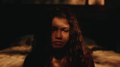 a woman with long hair standing in a dark room