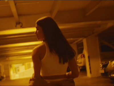 a woman standing in a parking garage next to a car