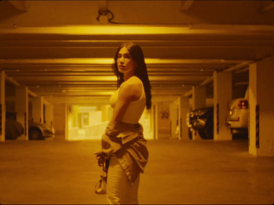 a woman standing in a parking garage holding an umbrella