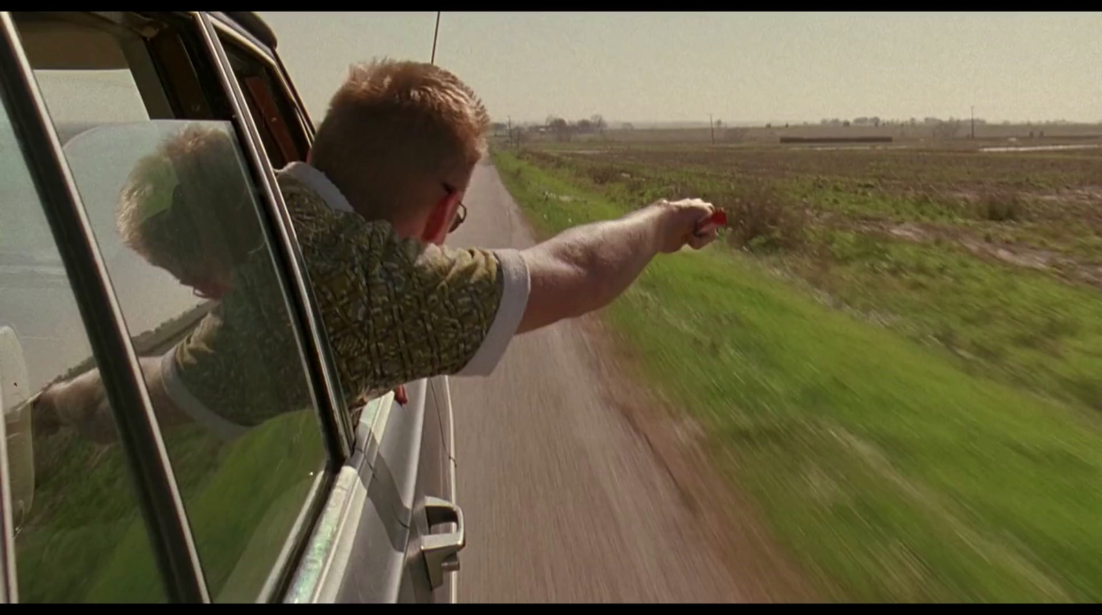 a man driving a car down a country road