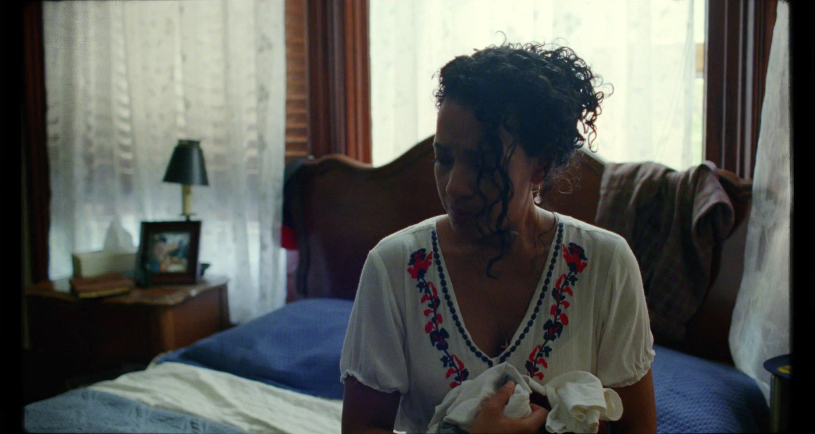 a woman sitting on a bed in a bedroom