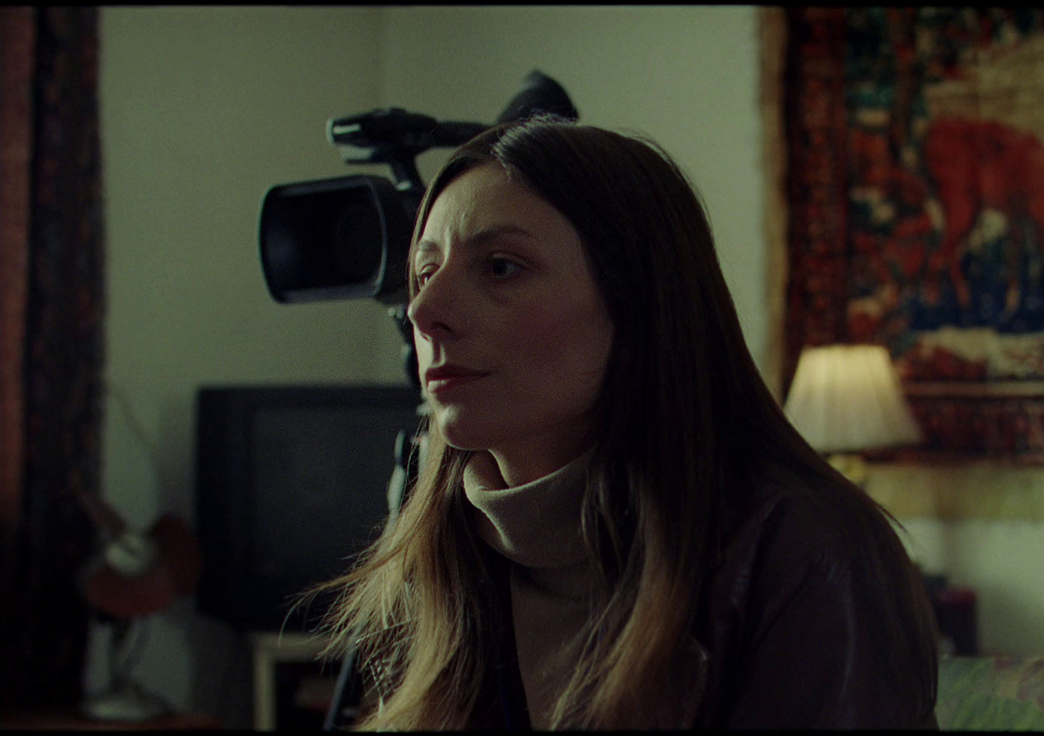 a woman standing in a living room next to a tv