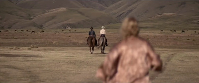 two people are riding horses in the desert