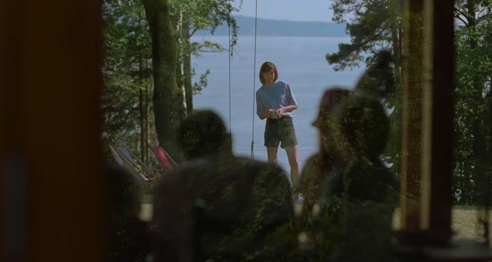 a man standing on a porch next to a lake