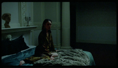 a woman sitting on a bed in a room