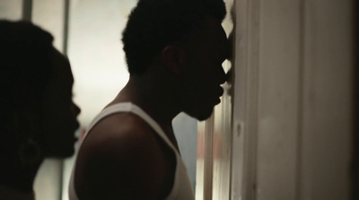 a man in a tank top standing in front of a mirror