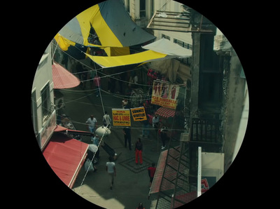 a group of people walking down a street next to buildings