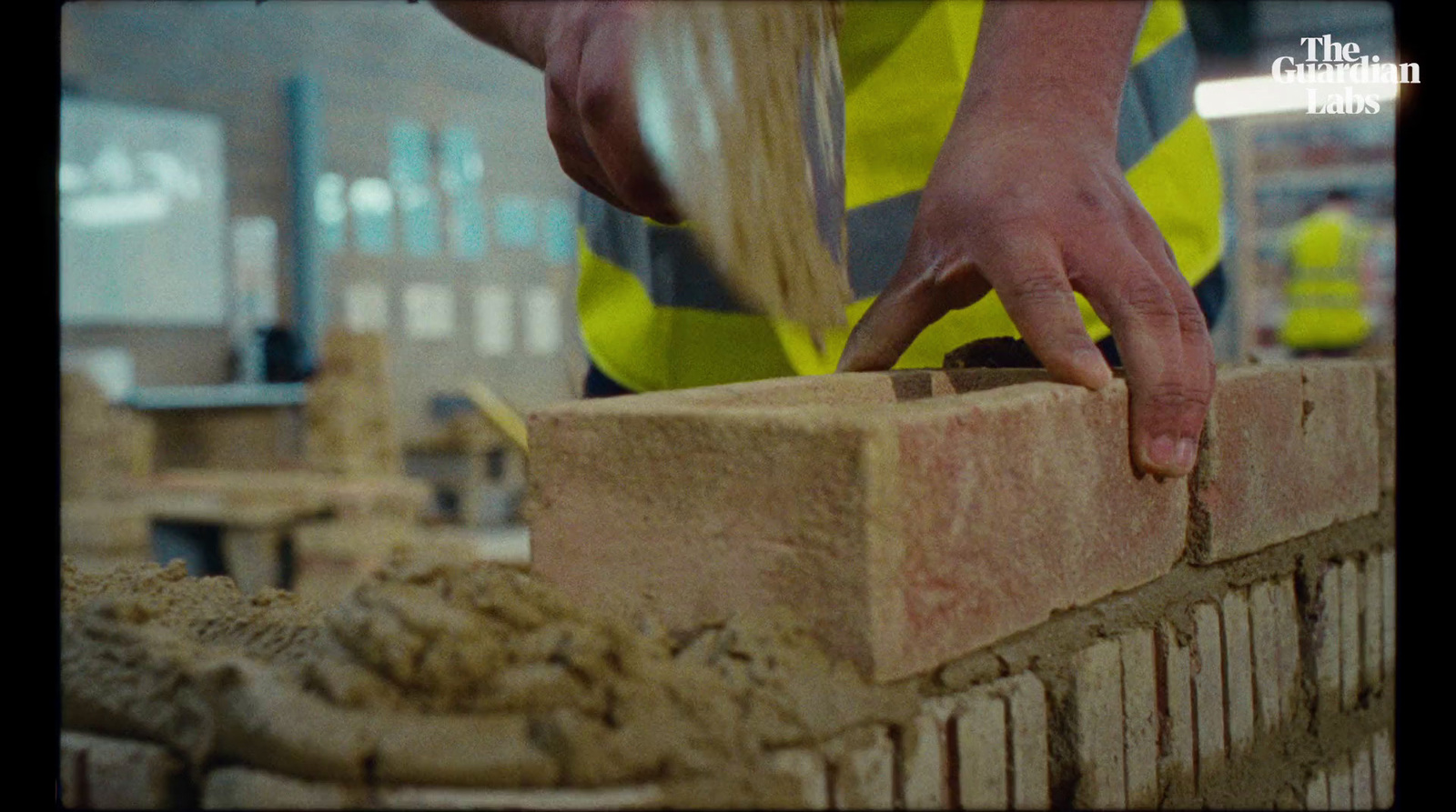 a construction worker placing bricks into a brick wall