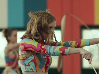 a woman in a colorful shirt holding a bow and arrow