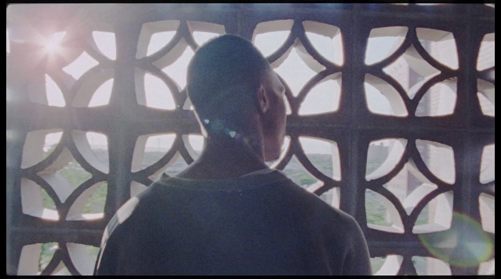 a man standing in front of a window looking out