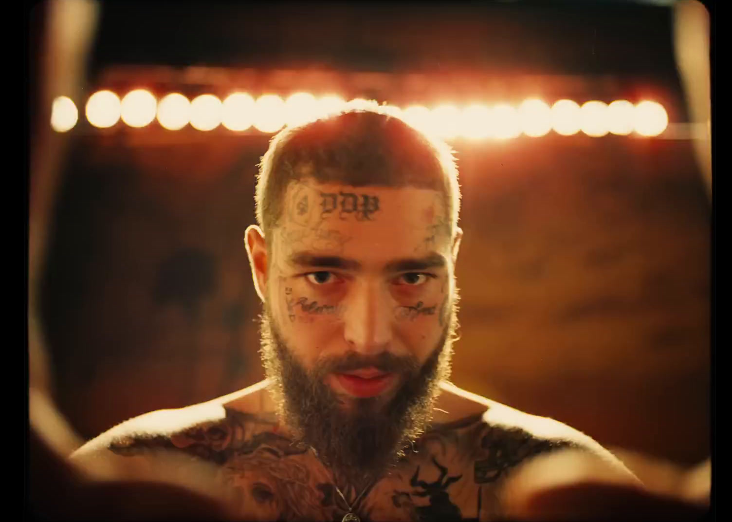 a man with tattoos on his face looking at the camera