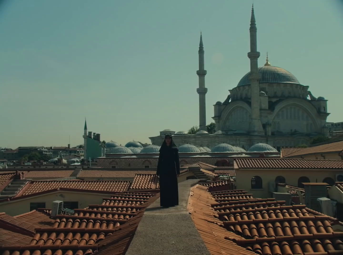 a woman standing on a roof in front of a building