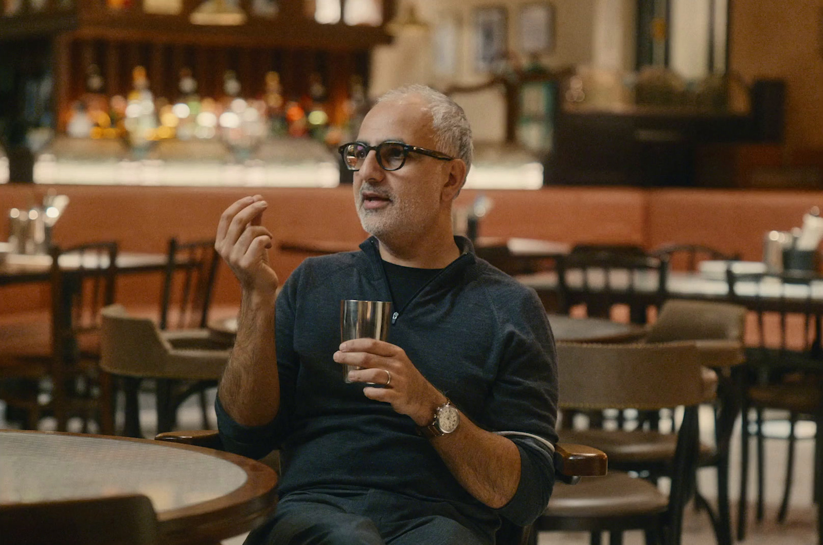 a man sitting at a table with a glass in his hand