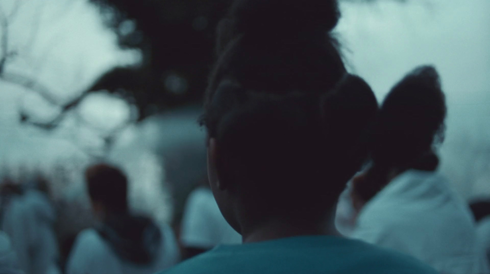 a blurry photo of a woman's back with people in the background