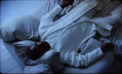 a person laying on a bed with a white blanket