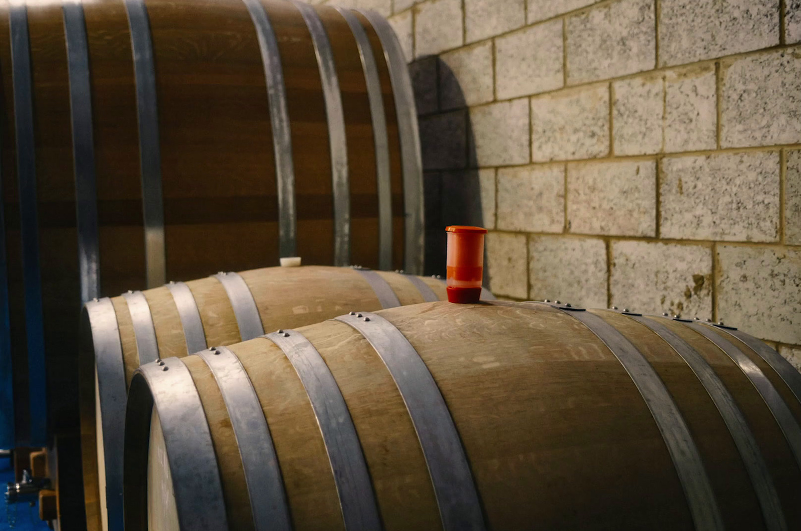 a red cup sitting on top of a wooden barrel