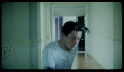 a man in white shirt standing in a hallway