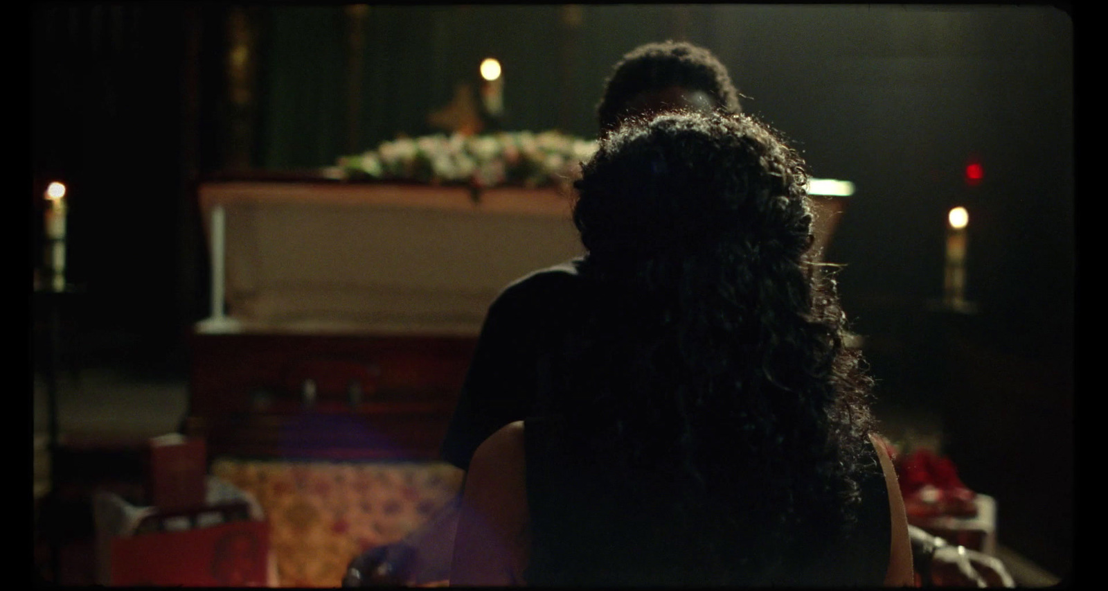 a woman with long dark hair standing in a dark room