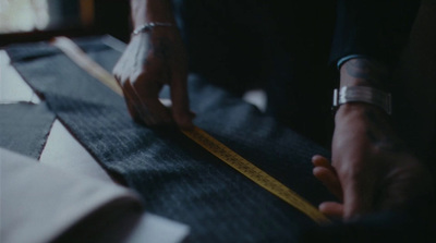 a person measuring a piece of fabric with a tape