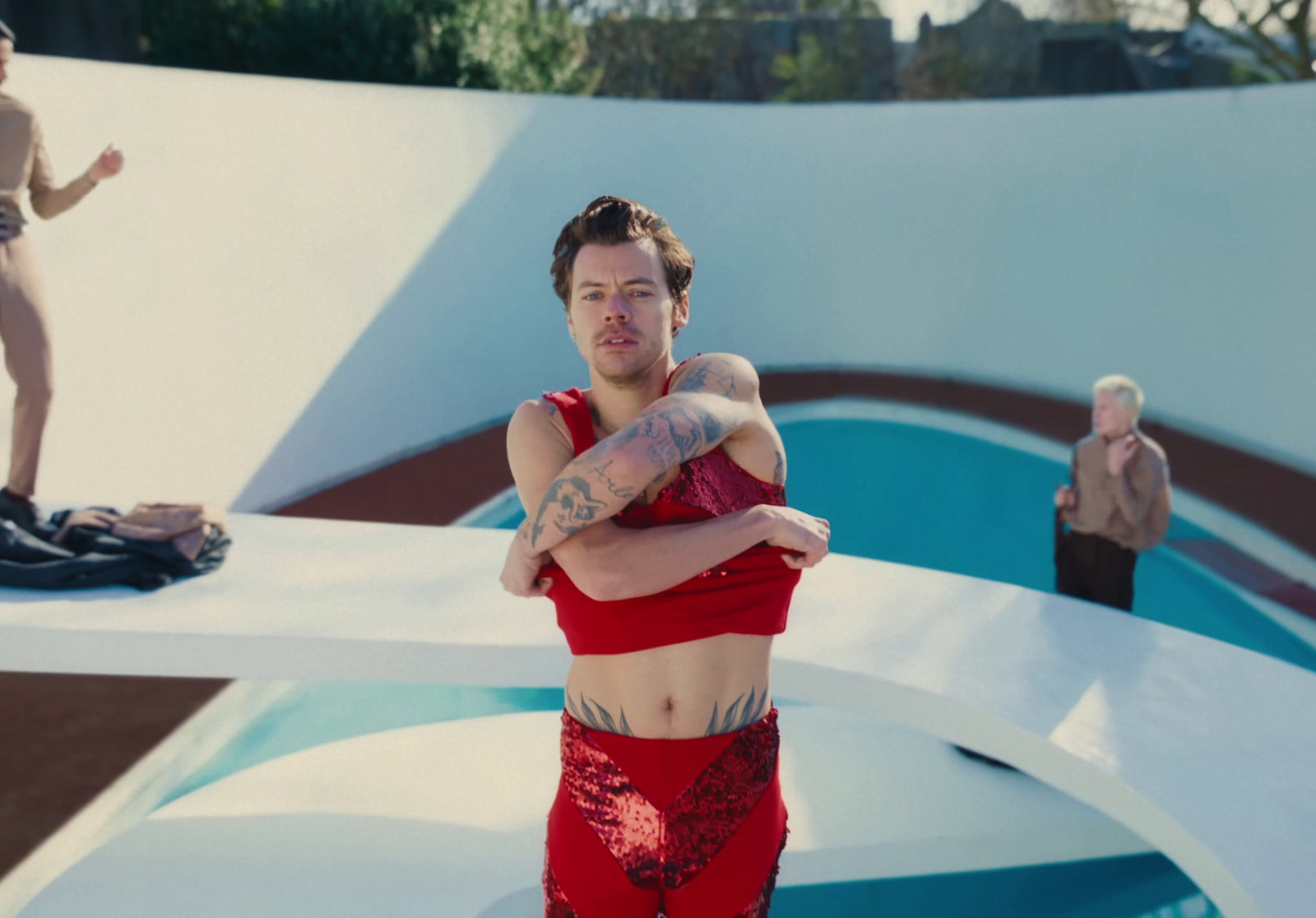 a man in a red outfit standing in front of a pool