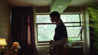 a woman standing in a living room next to a window