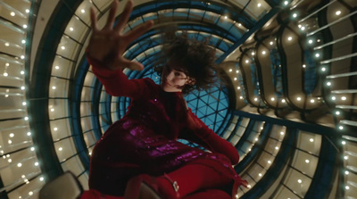 a woman in a red dress is sitting in a spiral object