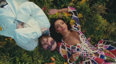 a man and a woman laying in a field of flowers