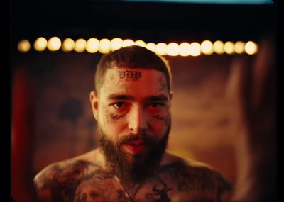 a man with tattoos and piercings standing in front of a mirror