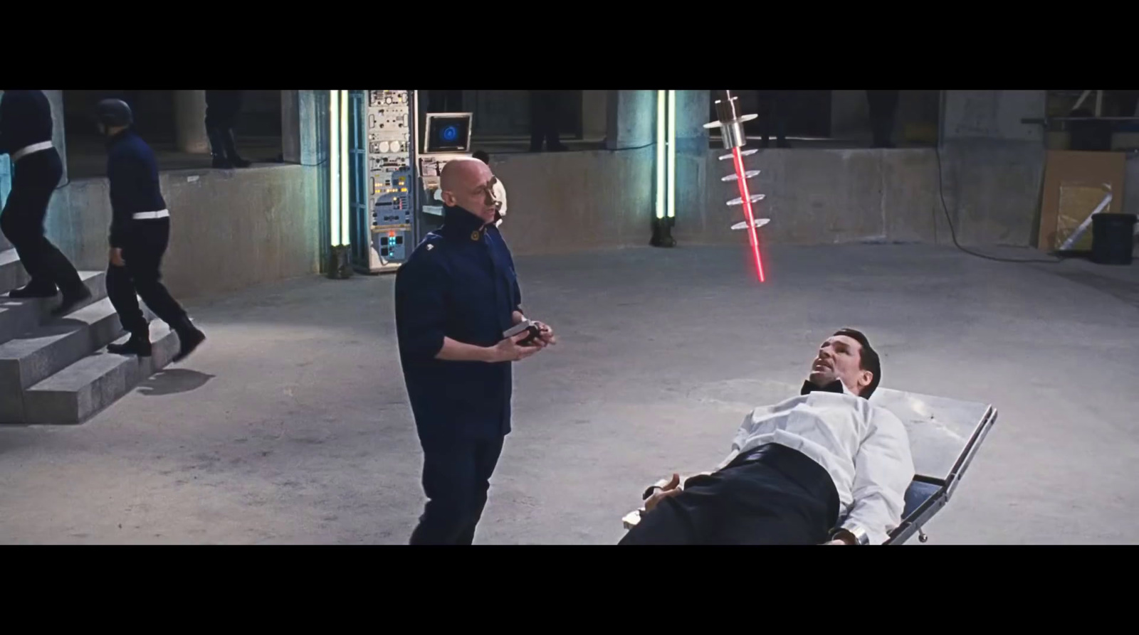 a man laying on the ground next to a man in a suit