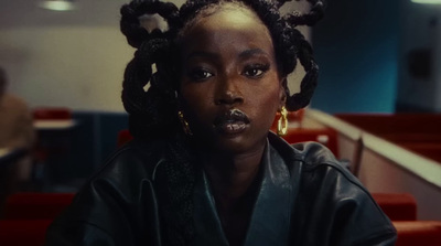 a woman sitting in a restaurant wearing a black jacket