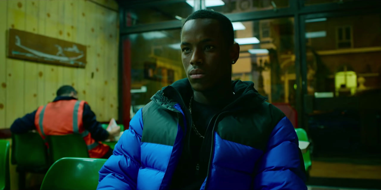 a man in a blue jacket sitting in a restaurant