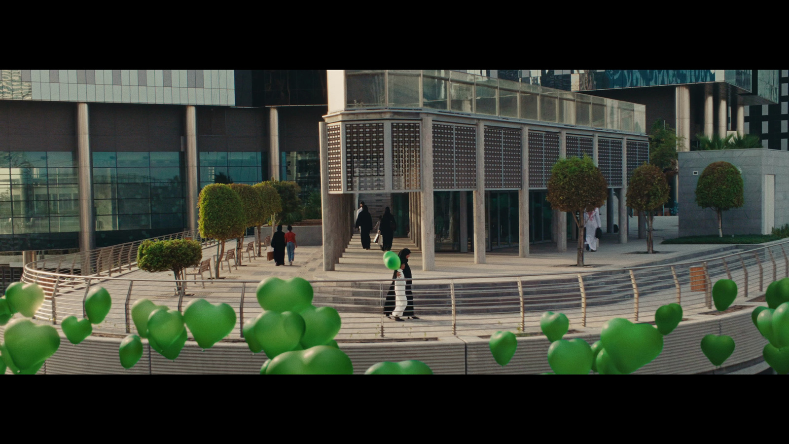 a group of people walking down a street next to a building