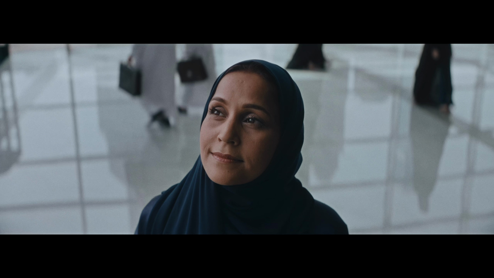 a woman in a black hijab is looking at the camera