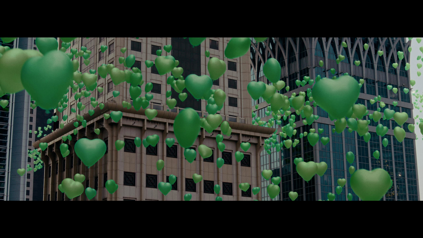 a bunch of green balloons floating in the air