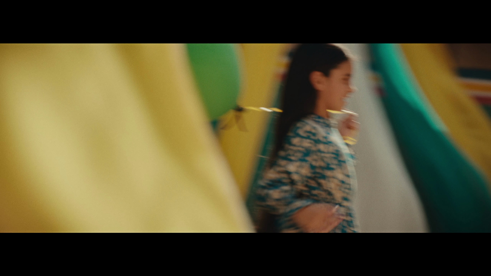 a woman standing in front of a yellow curtain