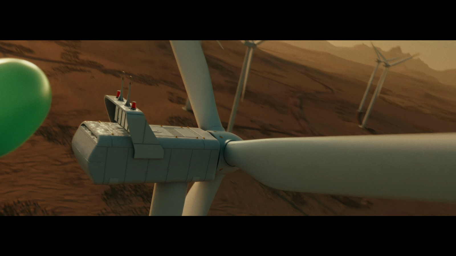 a green balloon is in front of a wind turbine