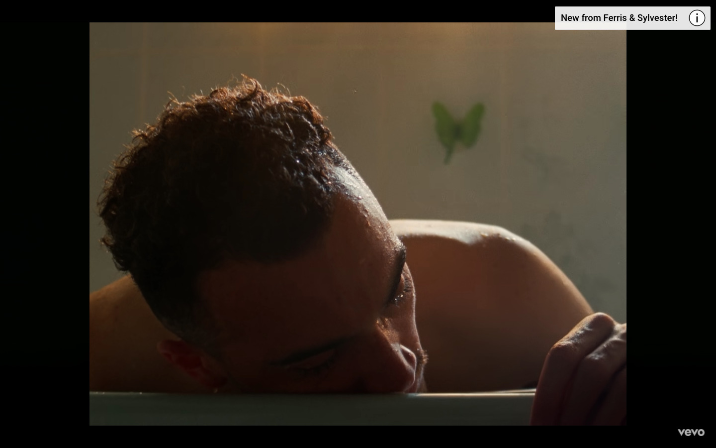 a man laying in a bathtub with his head on the edge of the tub