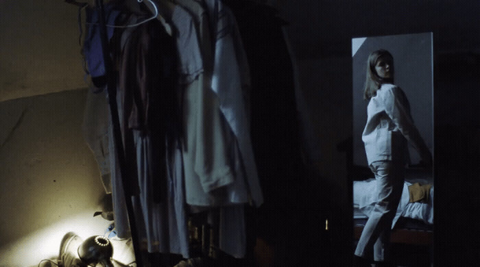 a woman standing in front of a mirror in a room