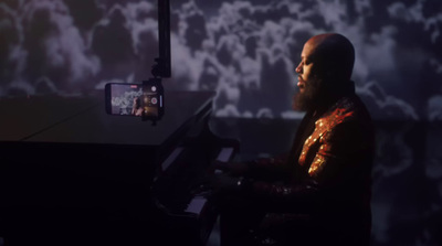 a man sitting at a piano in a dark room