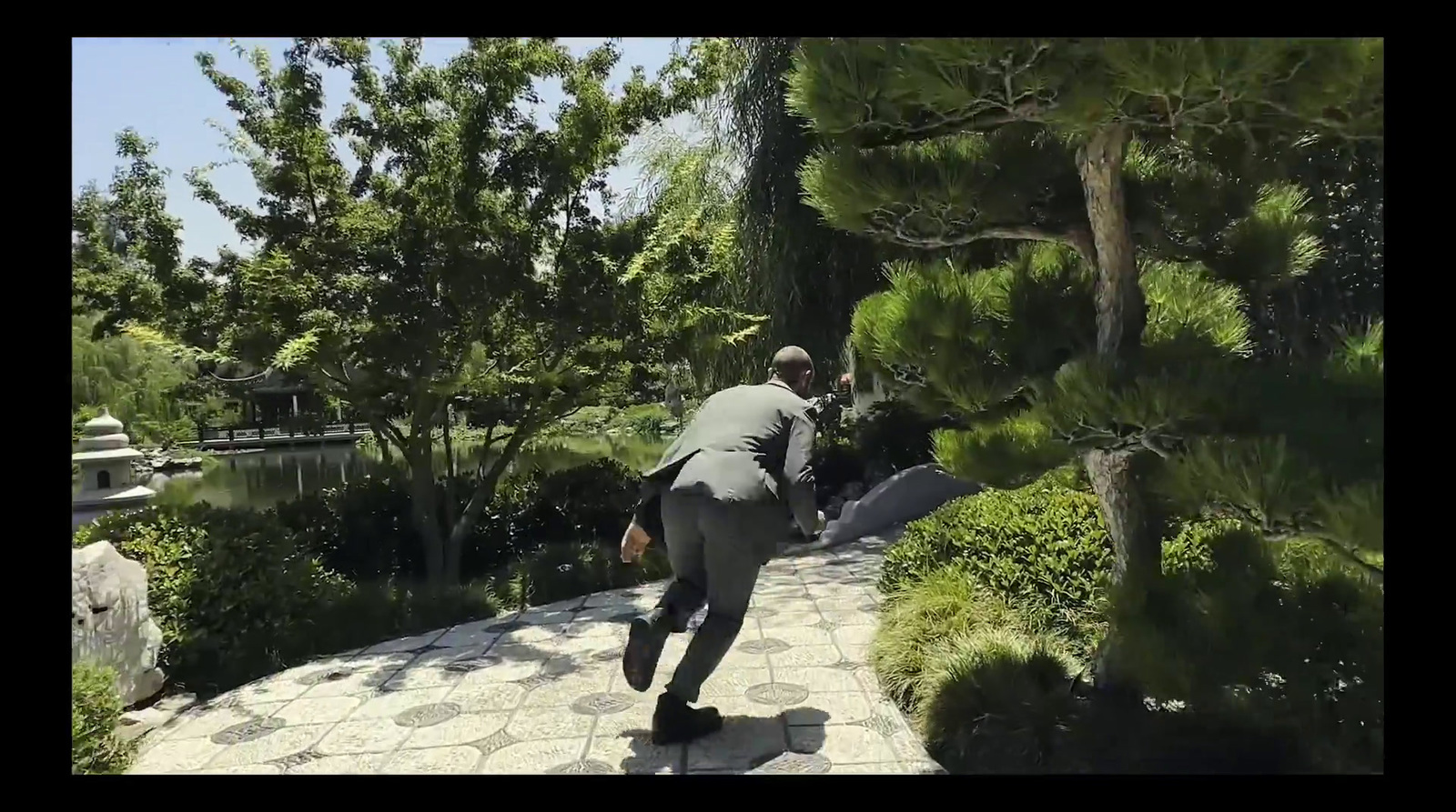 a man is walking down a path in a park