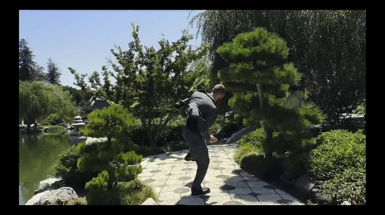 a man with a backpack walking through a garden