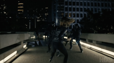 a group of people walking across a bridge at night