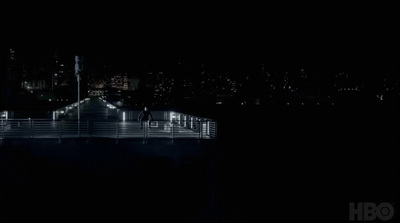 a night time view of a pier and city lights