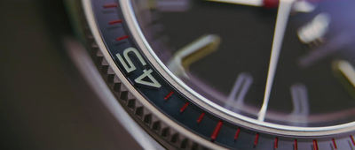 a close up of a watch with a red second hand