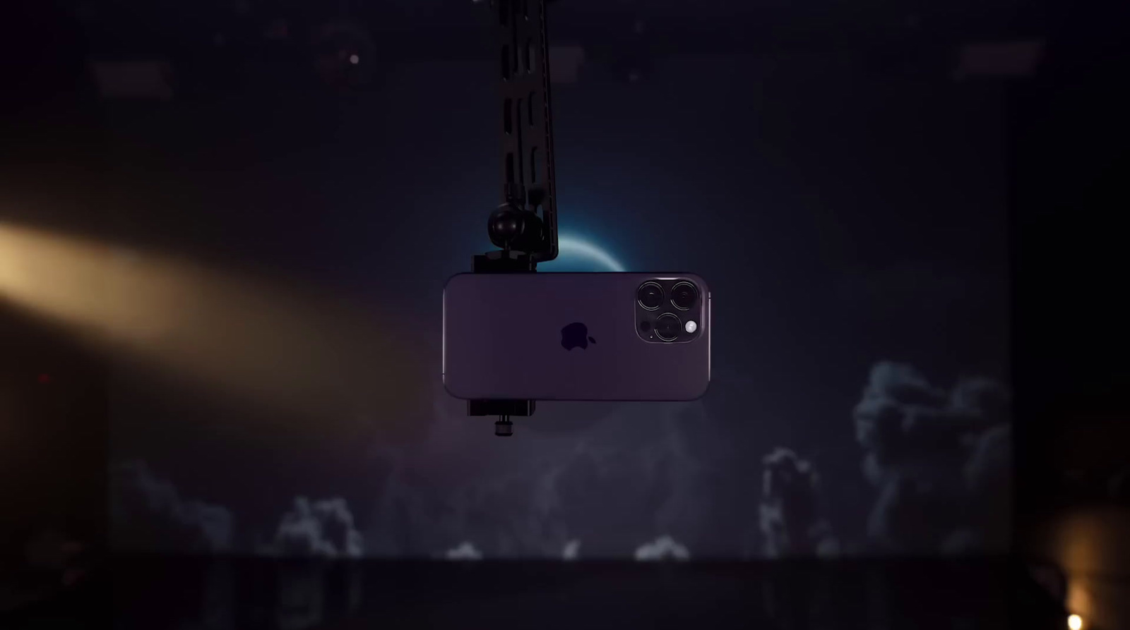 a cell phone hanging from a crane in a dark room