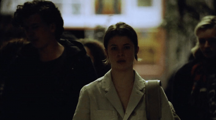 a woman walking down a street next to a man