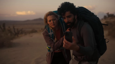 a man and a woman standing in the desert