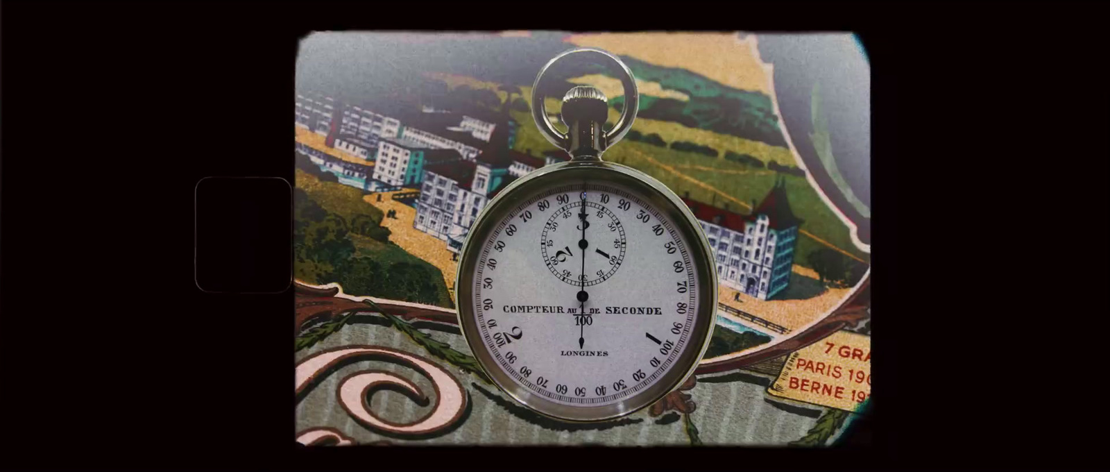 a picture of a pocket watch with a picture of a city in the background