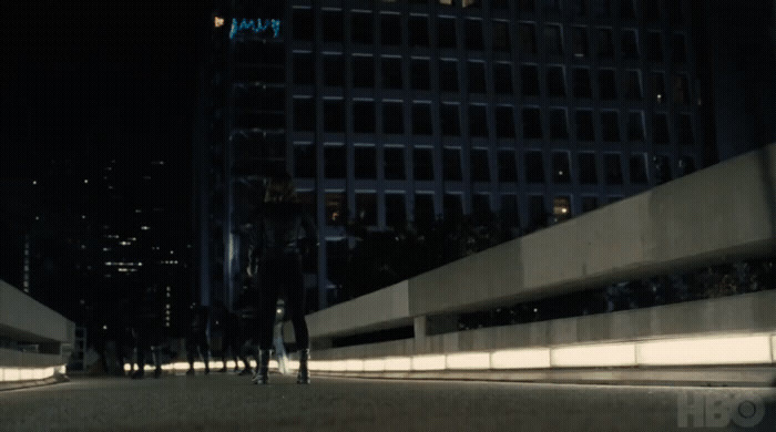 a group of people walking down a street at night