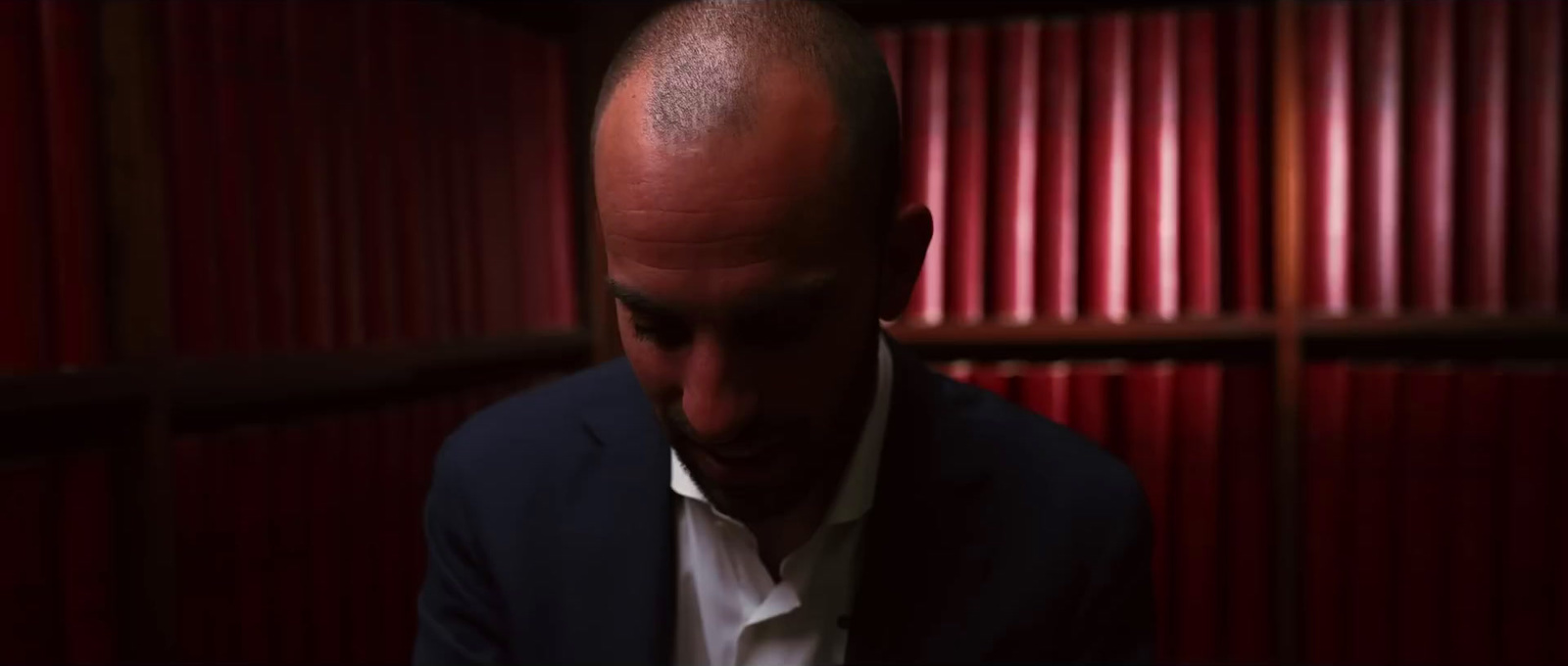 a man with a bald head in a dark room